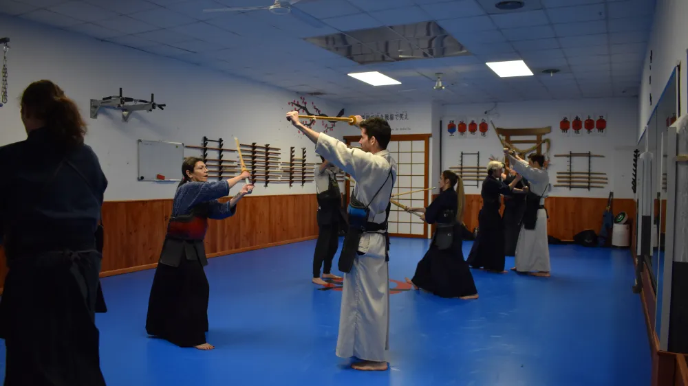Clase de kendo en Zaragoza: alumnos practicando suburi con el shinai en el dojo