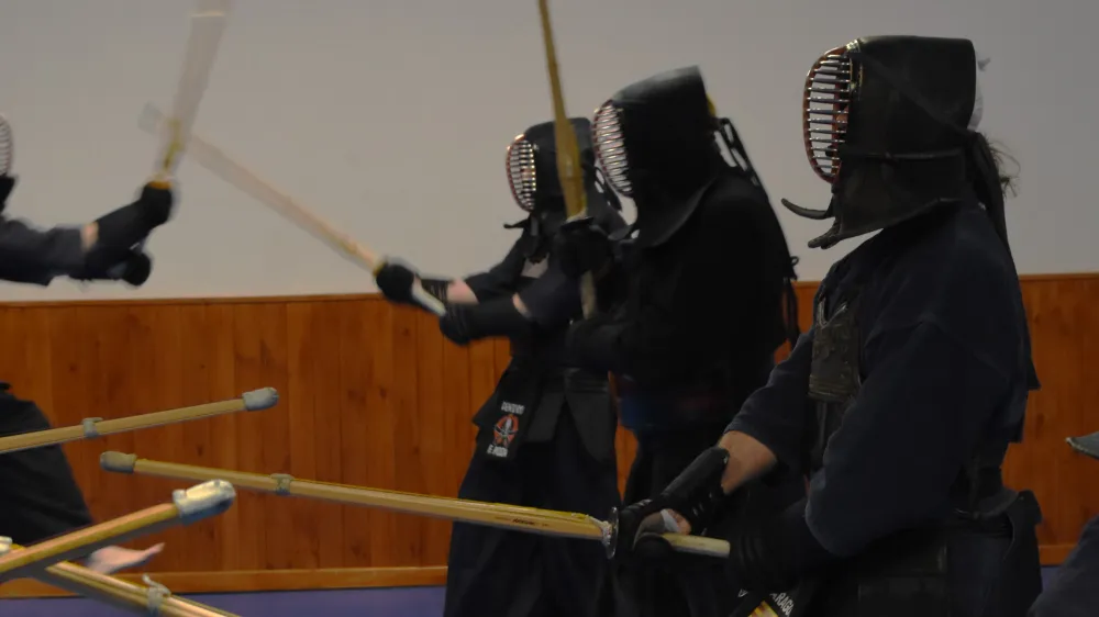 Detalle del men, el bogu y los shinai de varios practicantes de kendo